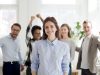 Portrait of successful female employee with excited colleagues a